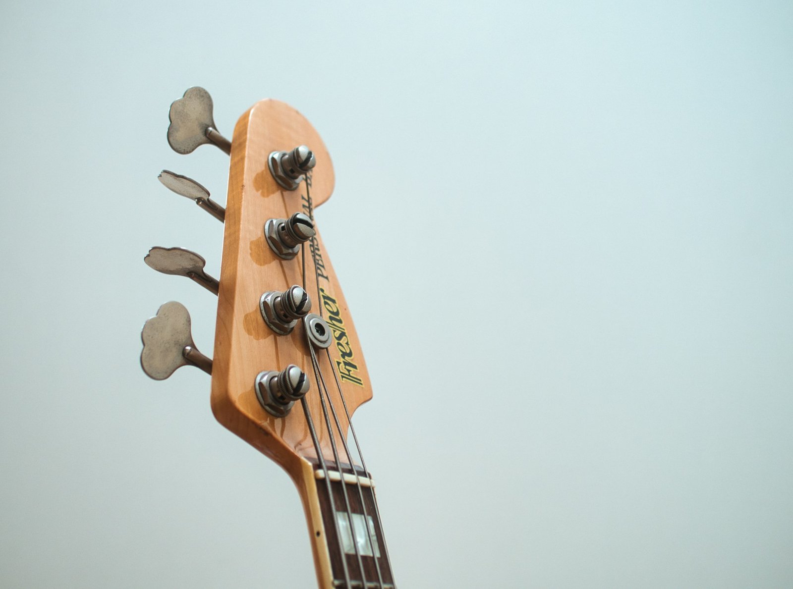 A bass guitar headstock with four tuning machines