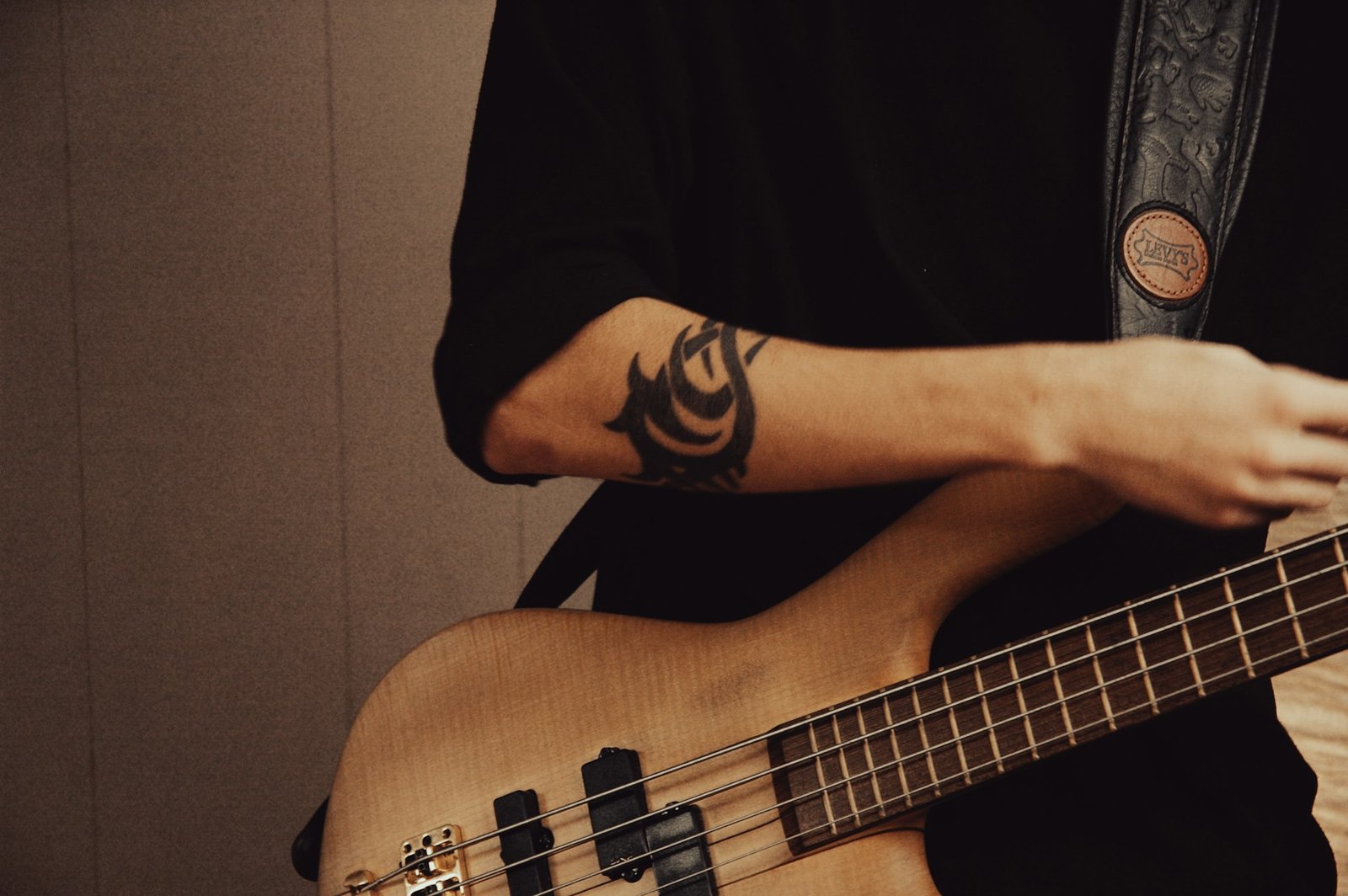 A bass player wearing a strap and playing a bass guitar