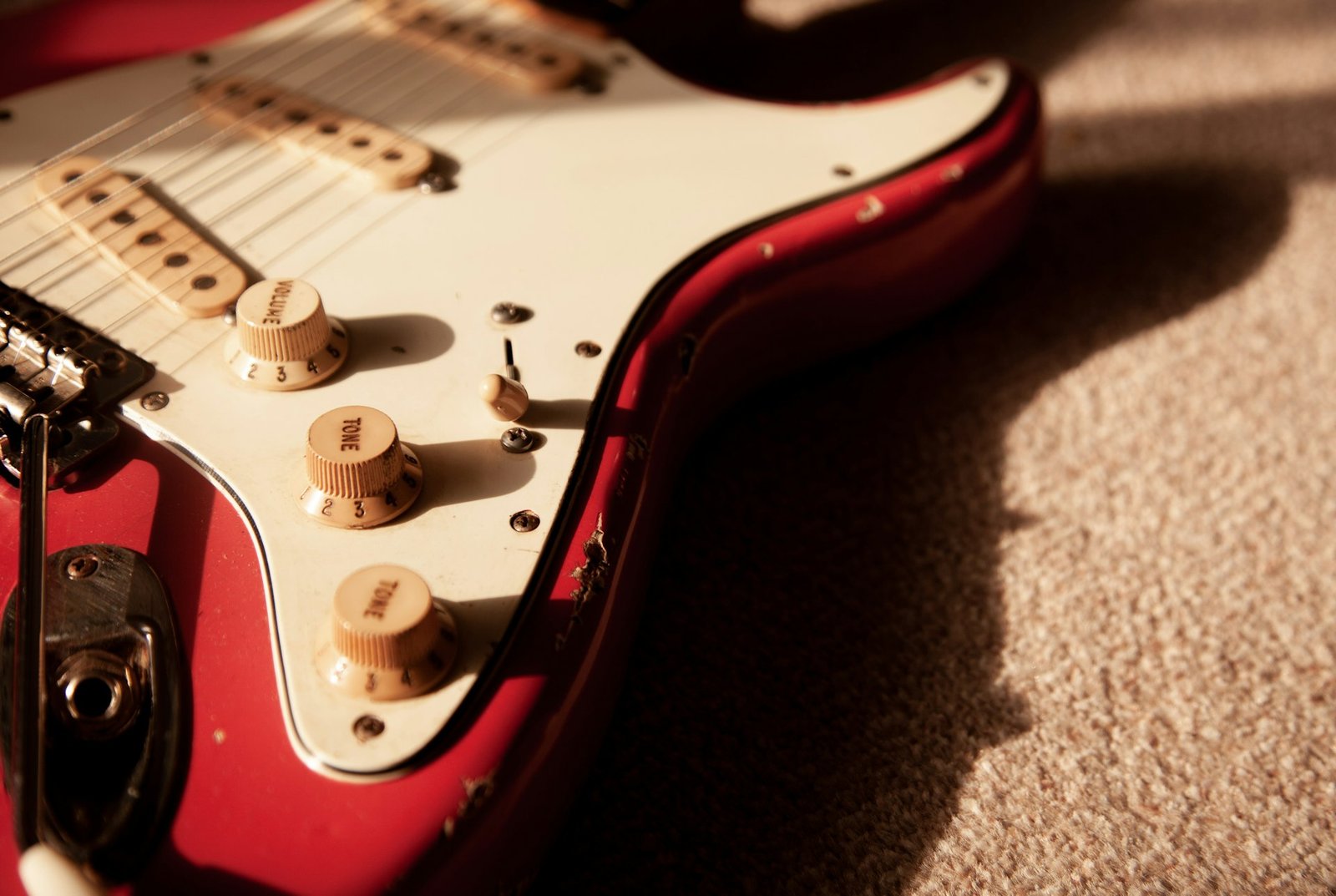 A shiny red and white electric guitar body close-up