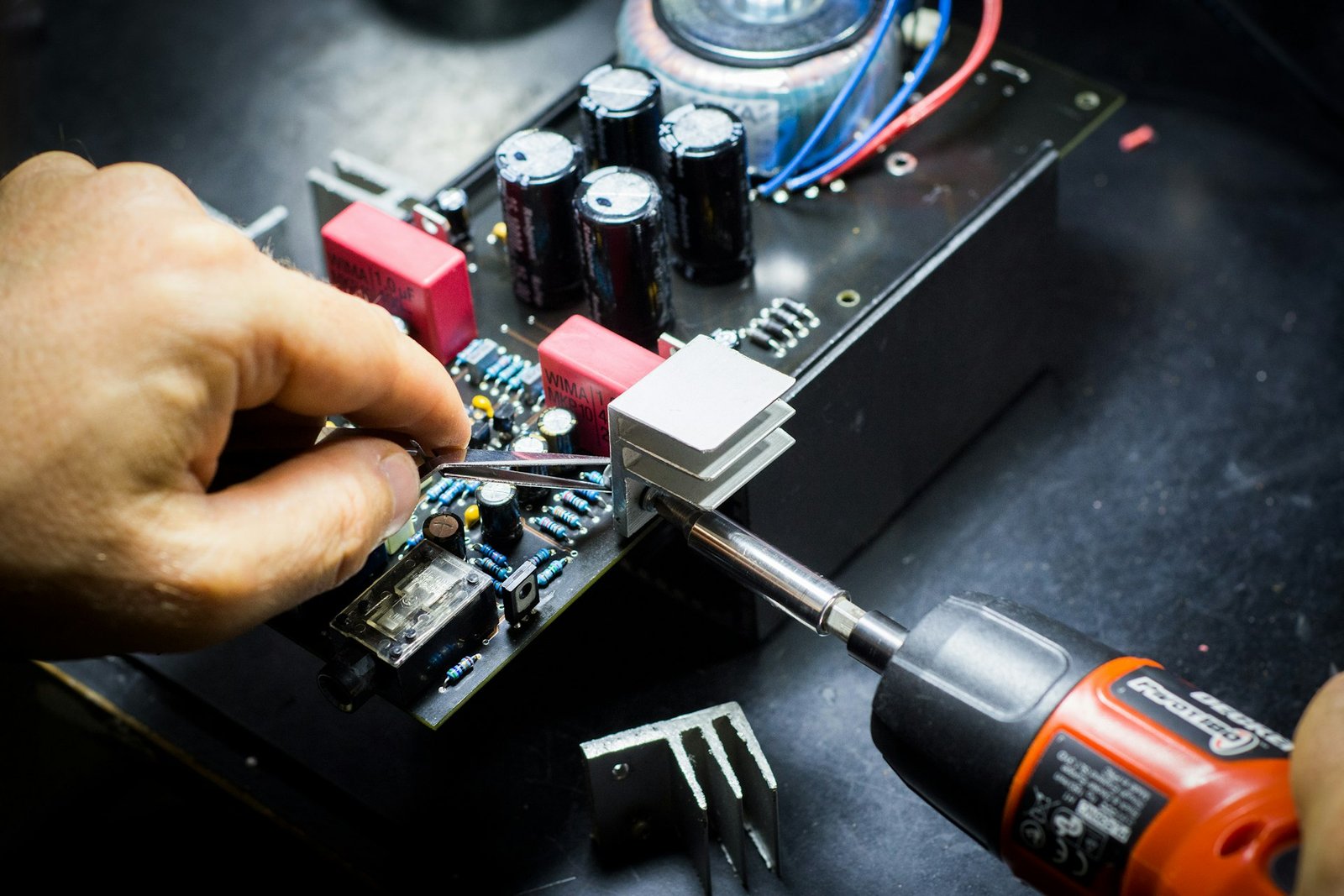 Hands repairing electronics on a circuit board